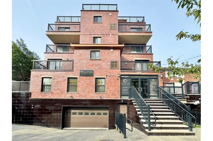 View of property featuring a garage, stairs, and concrete driveway