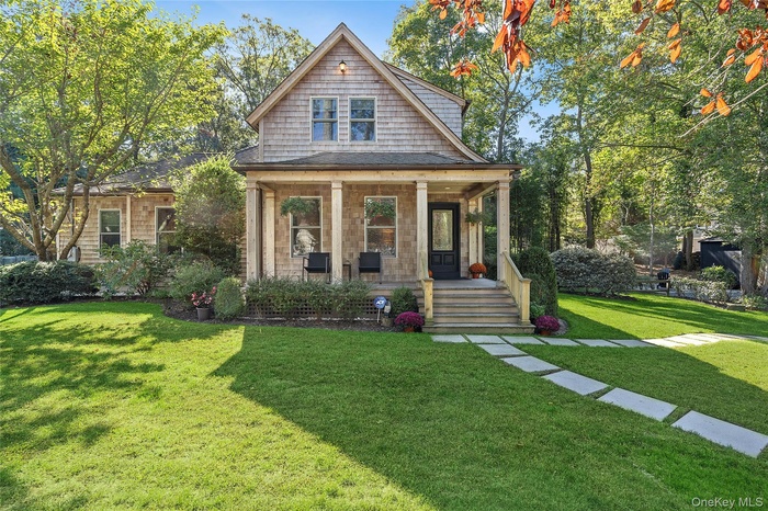 View of front of home with a porch and a front lawn