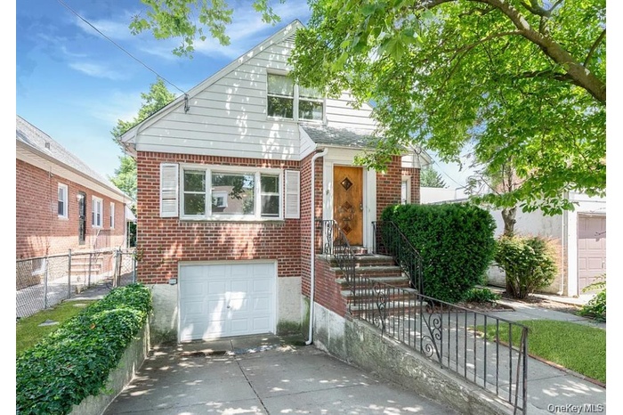 Bungalow with brick siding, concrete driveway, an attached garage, and a gate