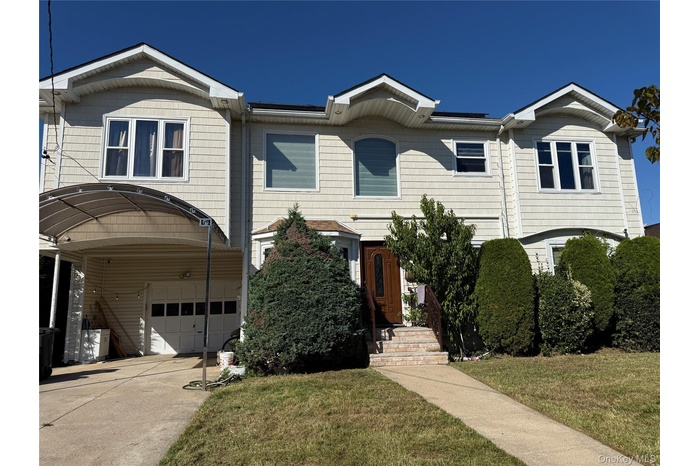 View of front of property featuring a garage, a front yard, and concrete driveway