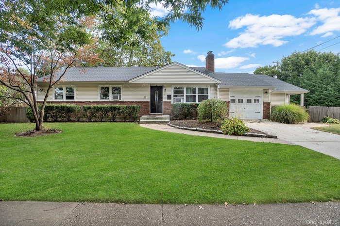 Ranch-style home featuring an attached garage, brick siding, a chimney, and concrete driveway