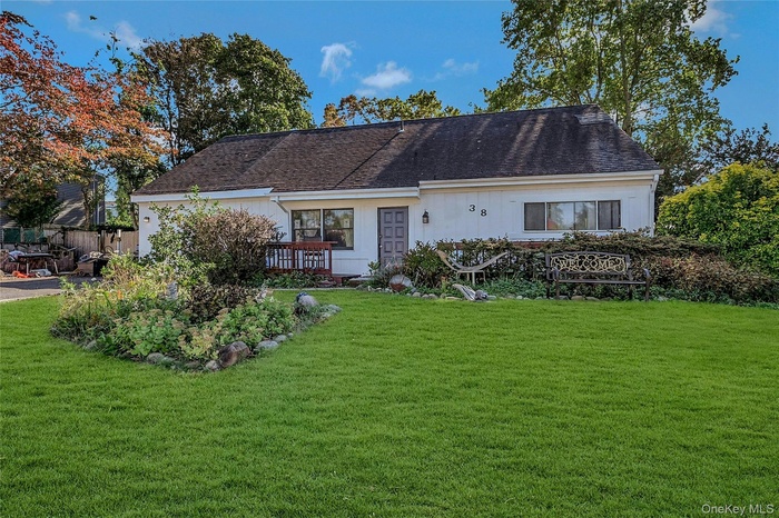 View of front facade featuring a front yard and roof with shingles