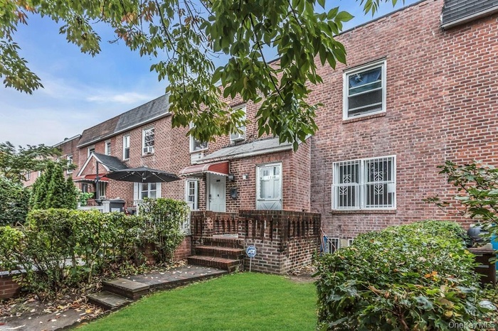 Back of house featuring brick siding and a lawn