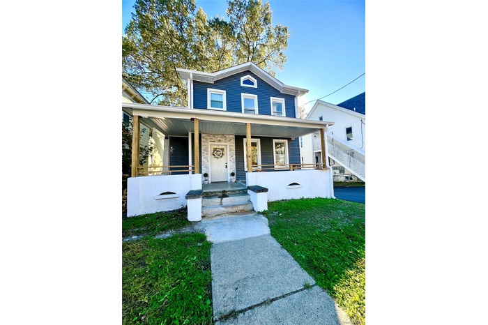 View of front of home with a porch and a front yard