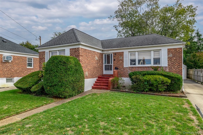 View of front of property with brick siding, roof with shingles, and entry steps
