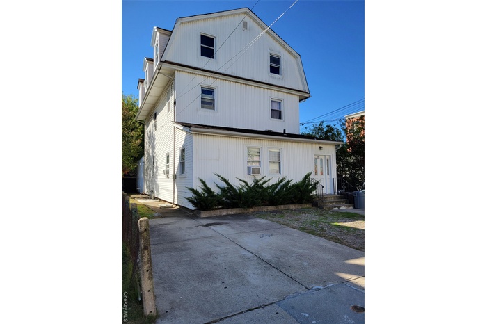 View of side of home with a gambrel roof