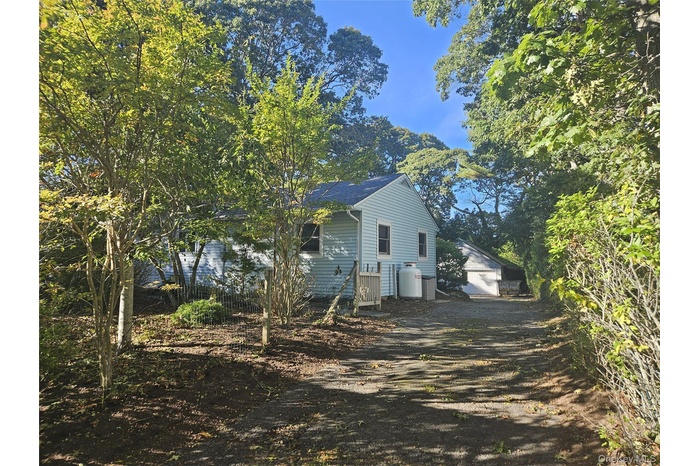 View of property exterior with an outbuilding, driveway, and a garage
