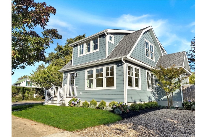 View of front of house with a shingled roof and a front yard