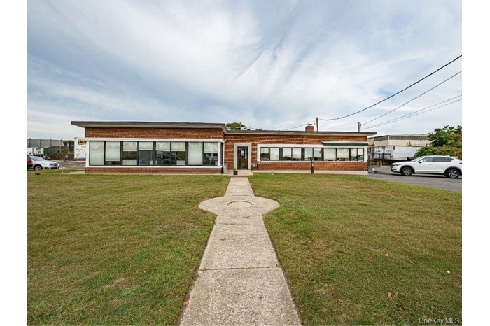 View of front facade with a front lawn, brick siding, and a chimney