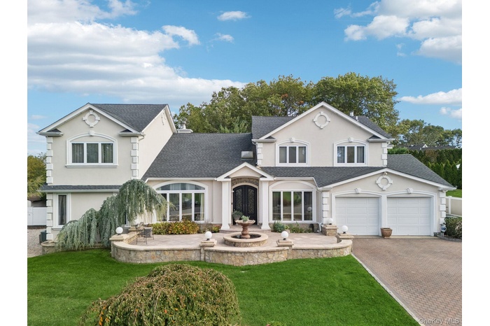 Traditional-style house with roof with shingles, stucco siding, and a front yard