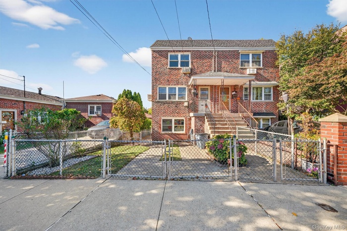 View of front of home with a gate, brick siding, and a fenced front yard