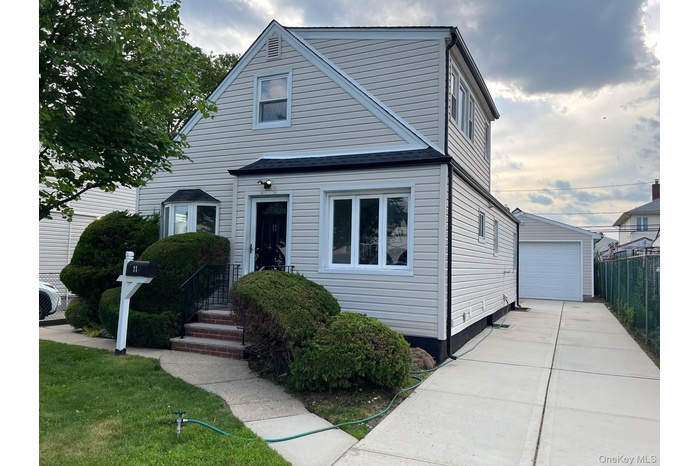 View of front of property featuring an outbuilding and a detached garage