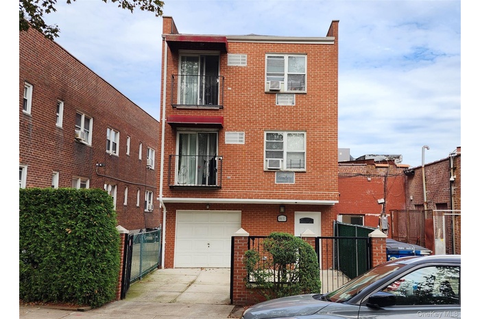 View of front of home with brick siding, a garage, and driveway