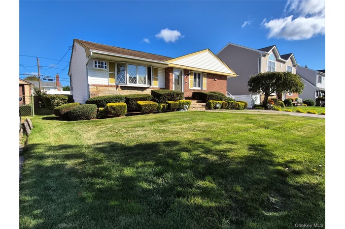 View of front of house with a front lawn and brick siding