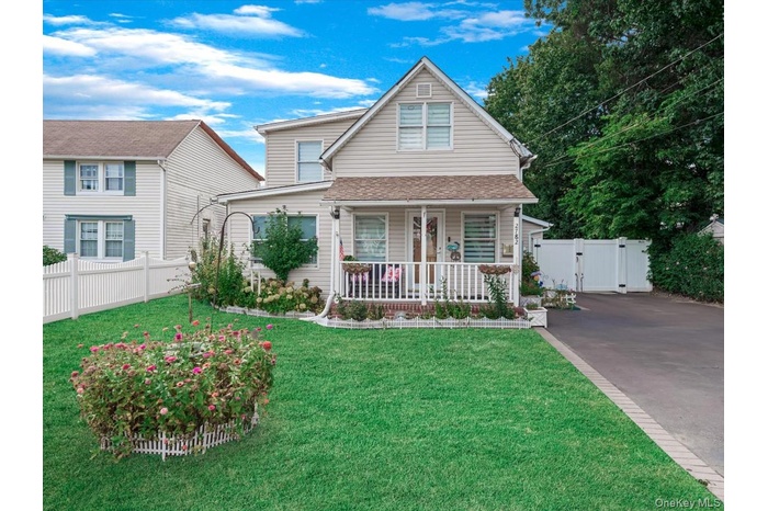 View of front of property featuring covered porch, a gate, driveway, and roof with shingles