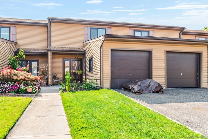 View of front of home with a front yard, a garage, and a porch