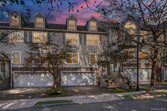 View of front of home featuring asphalt driveway and an attached garage