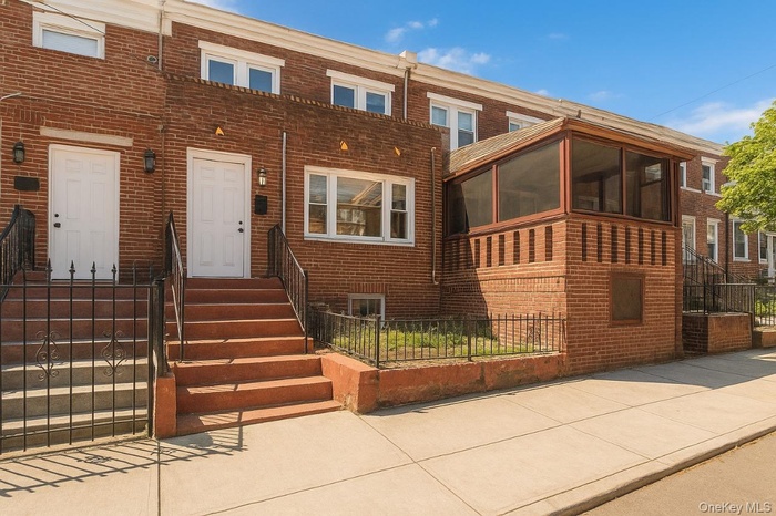 View of front of home featuring a sunroom and brick siding
