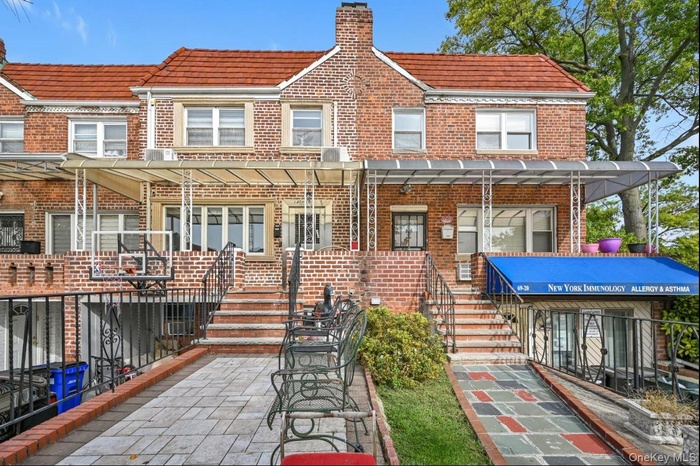 Rear view of property with brick siding and stairs