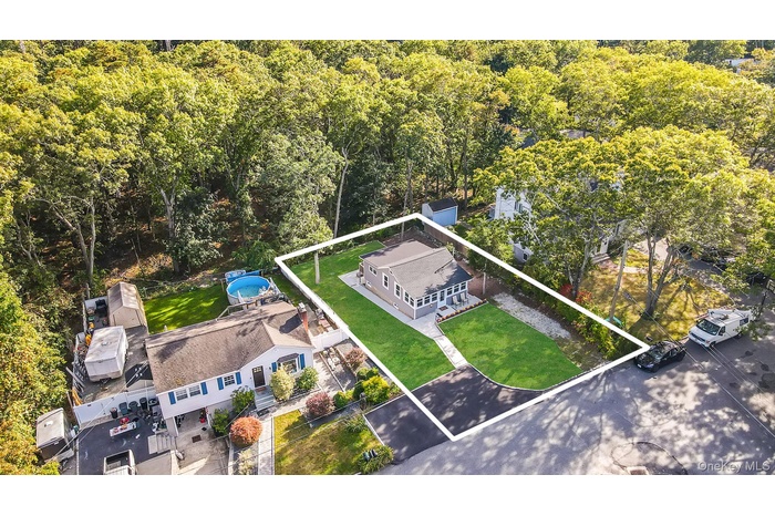 View from above of property featuring property parcel outlined and a forest
