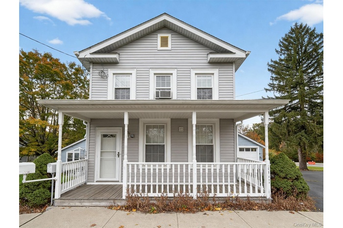 View of front of property with a porch and a garage