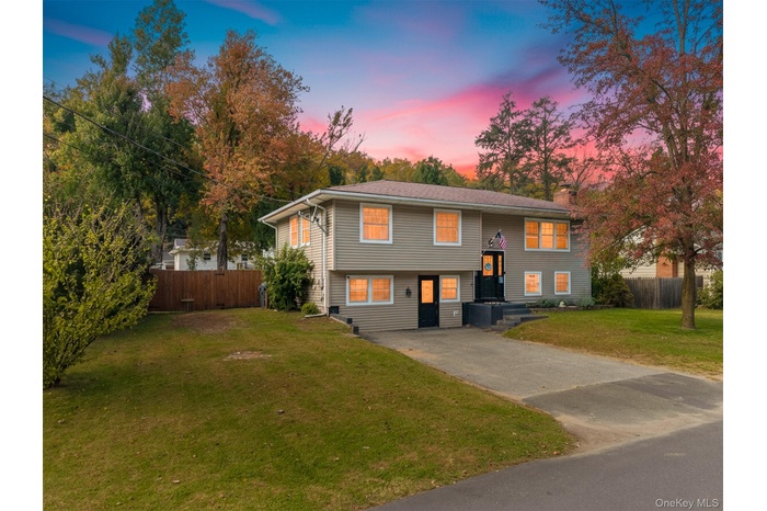Bi-level home with driveway and a chimney