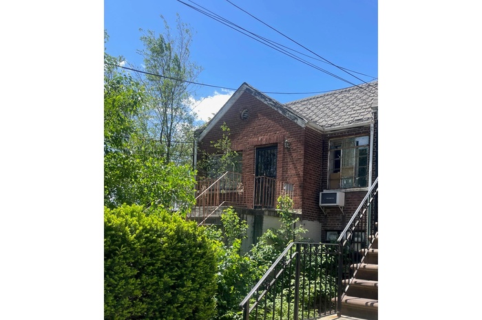 View of front of house with stairway and brick siding