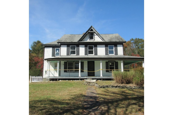 Farmhouse inspired home with a porch and a front lawn