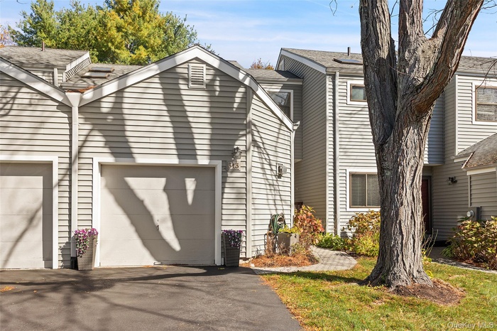 Front view with attached garage and enough space for 2 cars on the driveway.