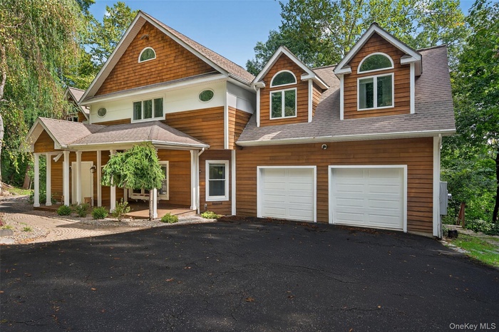 Craftsman inspired home with a shingled roof, driveway, and a garage