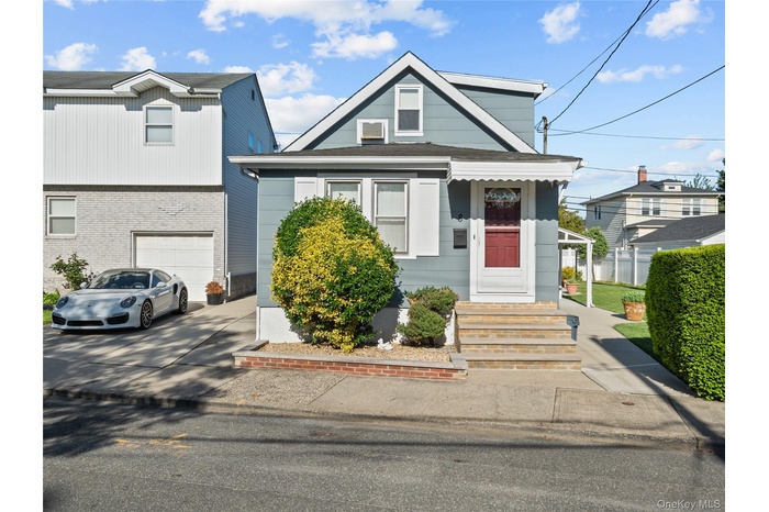 View of front of property featuring a garage and concrete driveway