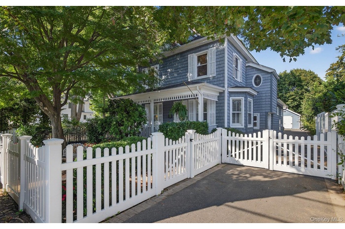 View of front of home with a gate, a fenced front yard, and covered porch