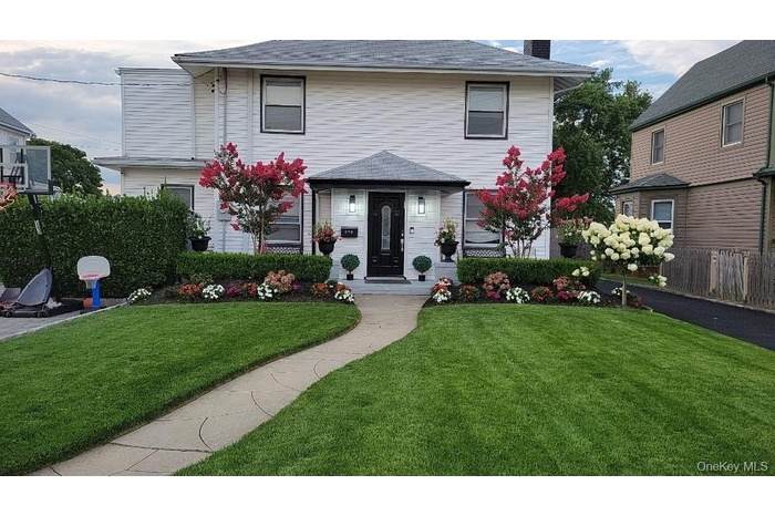 View of front of property with a chimney and roof with shingles