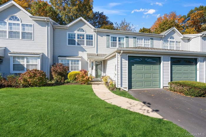 Traditional-style house featuring a front lawn and driveway