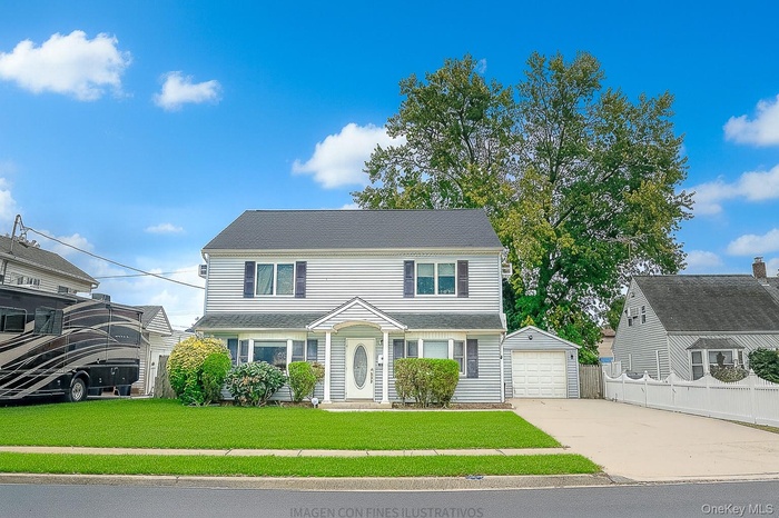 View of front facade featuring driveway, an outdoor structure, and a detached garage