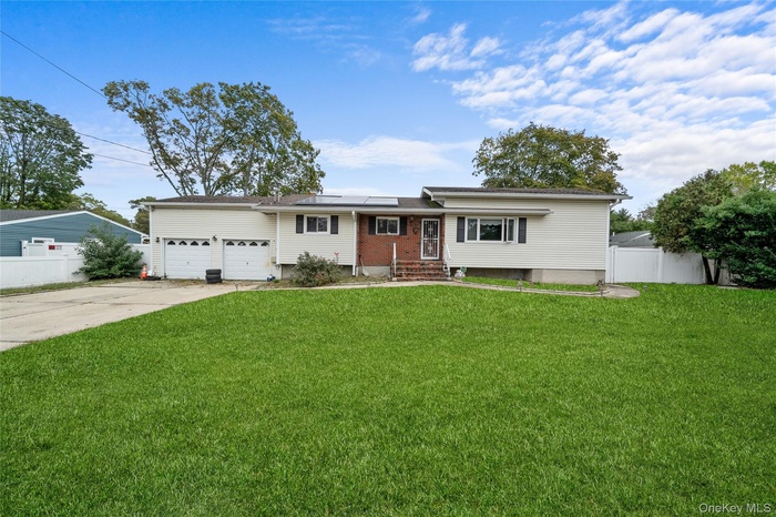 View of front of property with concrete driveway, roof mounted solar panels, a garage, and entry steps