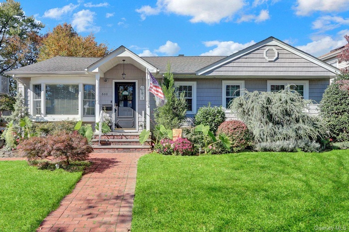 Single story home featuring a front yard and roof with shingles