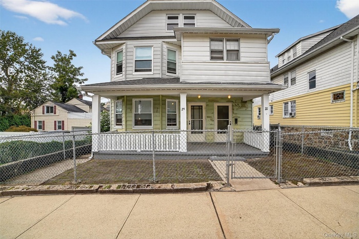 View of front of home with a gate, a fenced front yard, and a porch