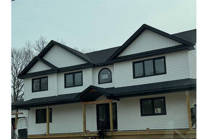 View of front of home featuring board and batten siding, a porch, and roof with shingles