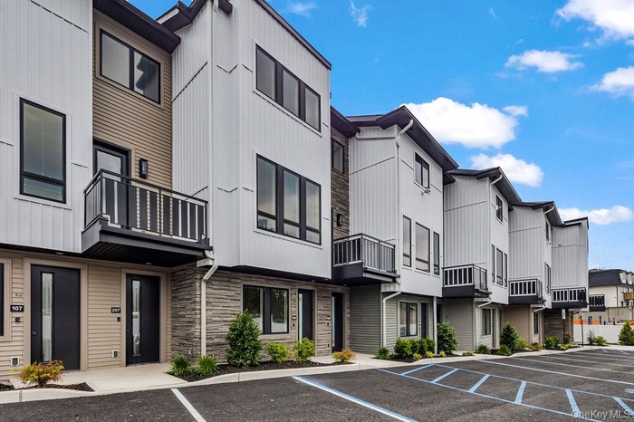 View of property with a residential view and uncovered parking