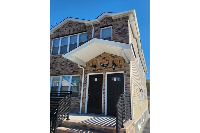 Entrance to property with a porch and stone siding