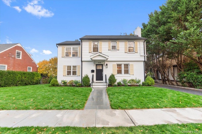 View of front of property featuring a front yard and a chimney