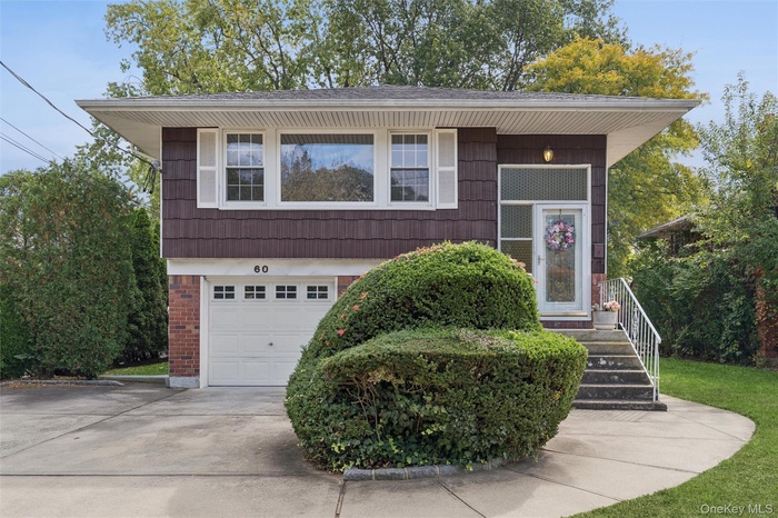 View of front of home featuring brick siding, an attached garage, and driveway