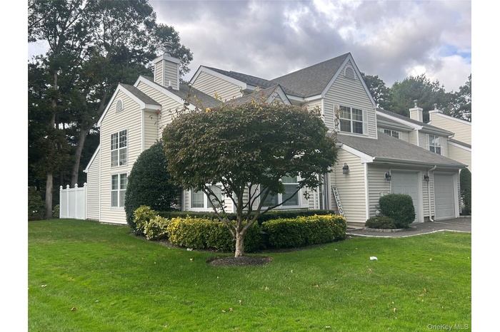 View of side of property featuring roof with shingles and asphalt driveway