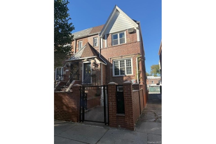View of front of house with a fenced front yard, a gate, and brick siding