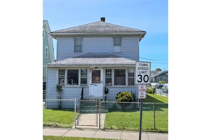 American foursquare style home featuring a gate, a fenced front yard, a chimney, and a shingled roof