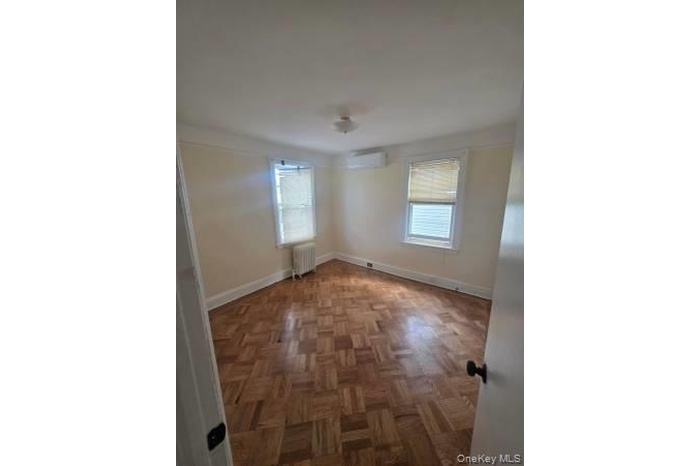 2nd Floor Unfurnished room featuring radiator heating unit and a wall mounted air conditioner