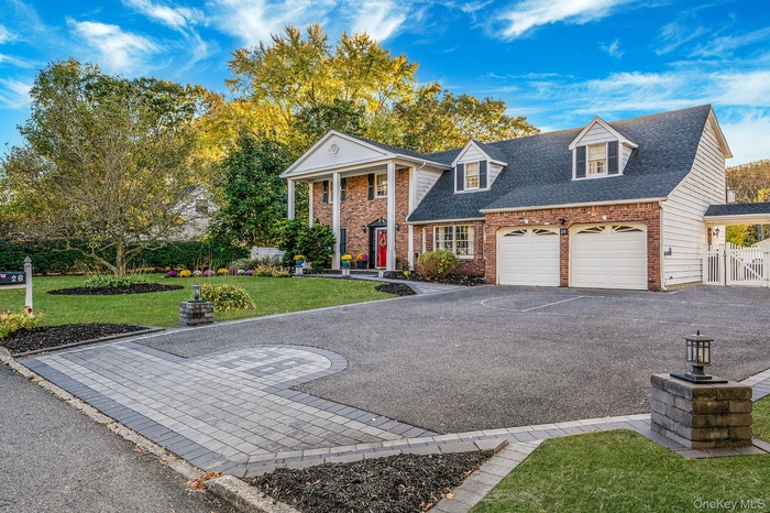 Greek revival inspired property with a front yard, a shingled roof, brick siding, driveway, and a porch