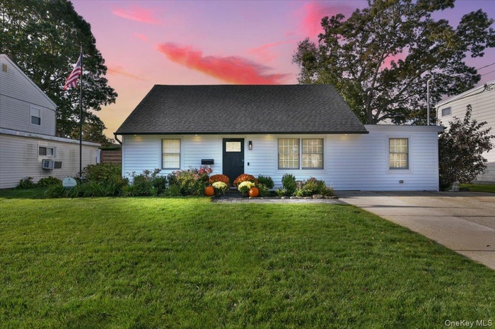 View of front of house with a front lawn and a shingled roof