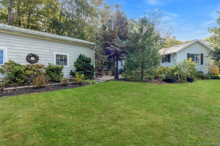 View of grassy yard featuring oil tank and a patio